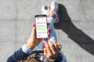 Image of woman looking at phone calendar with a lot of appointments